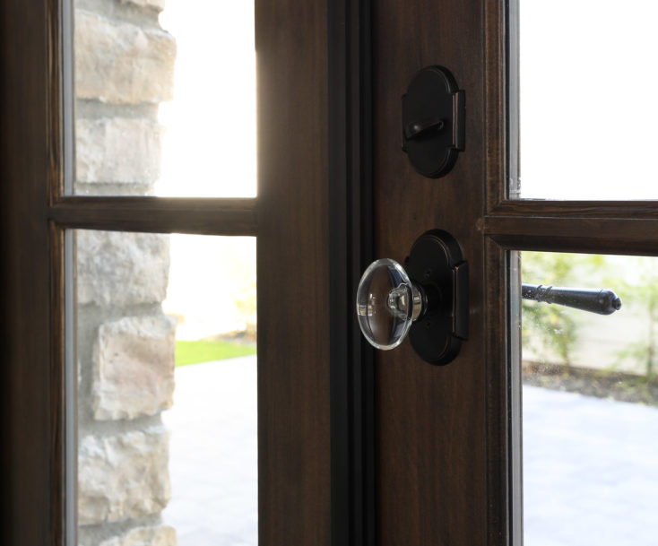 Crystal handle on wooden french doors on home designed by Hollie Whitehead